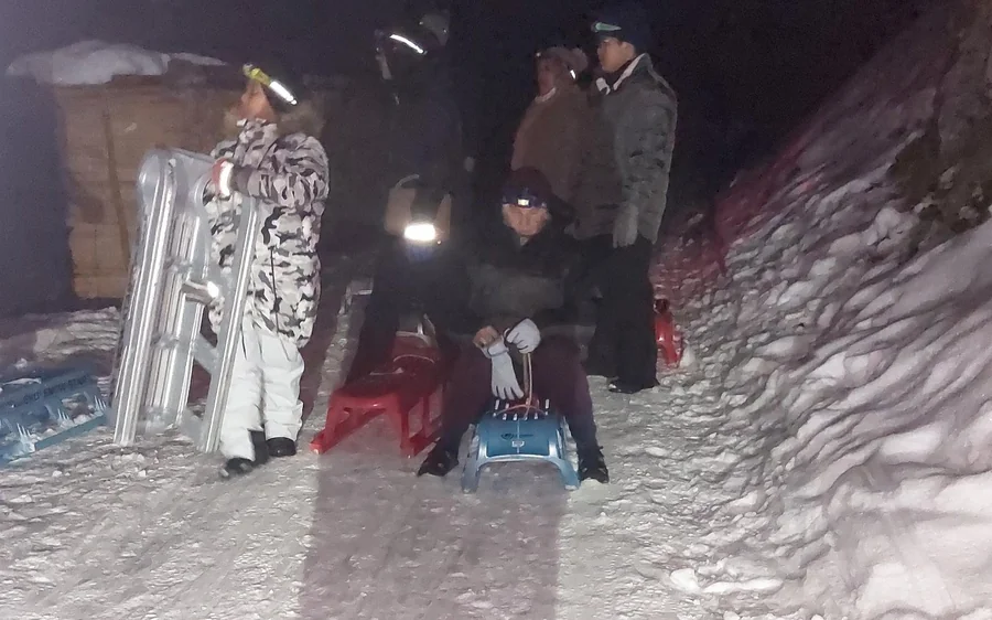 A sled run above Interlaken under the light of headlamps